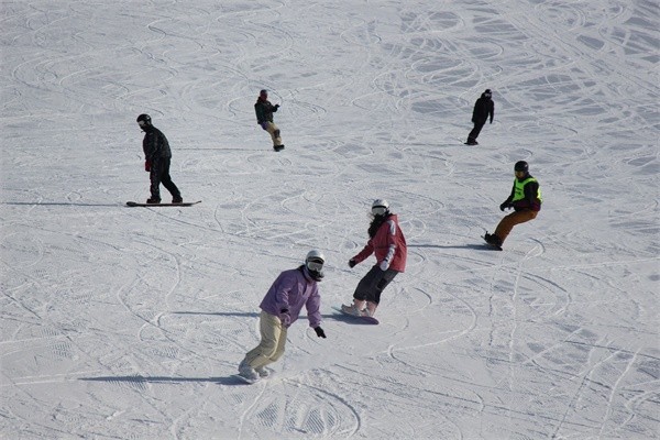 □滑雪爱好者在雪场飞驰而下。