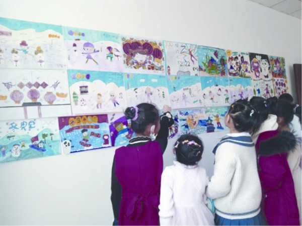 □和布克赛尔蒙古自治县和什托洛盖镇阳光社区的孩子们在参观儿童绘画冬奥作品。