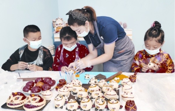□沙湾市三道河子镇天山路社区的孩子们在老师的指导下，一起制作北京冬奥会吉祥物。