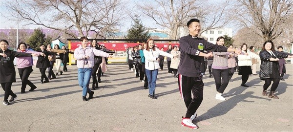 □3月4日，裕民县第一小学的男老师教女老师跳广场舞，充满了欢快的气氛。