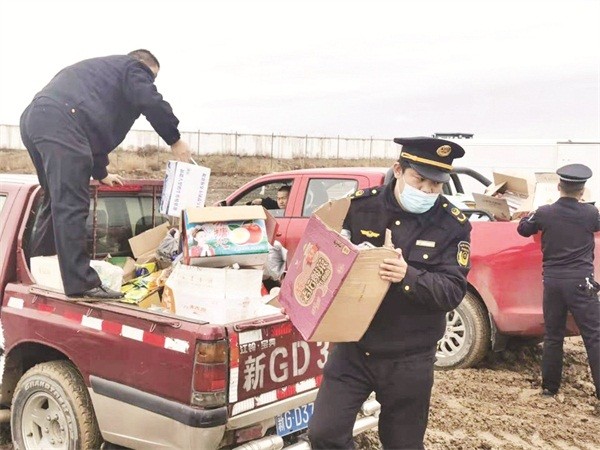 □裕民县市场监督管理局工作人员搬运准备销毁的侵权假冒商品。